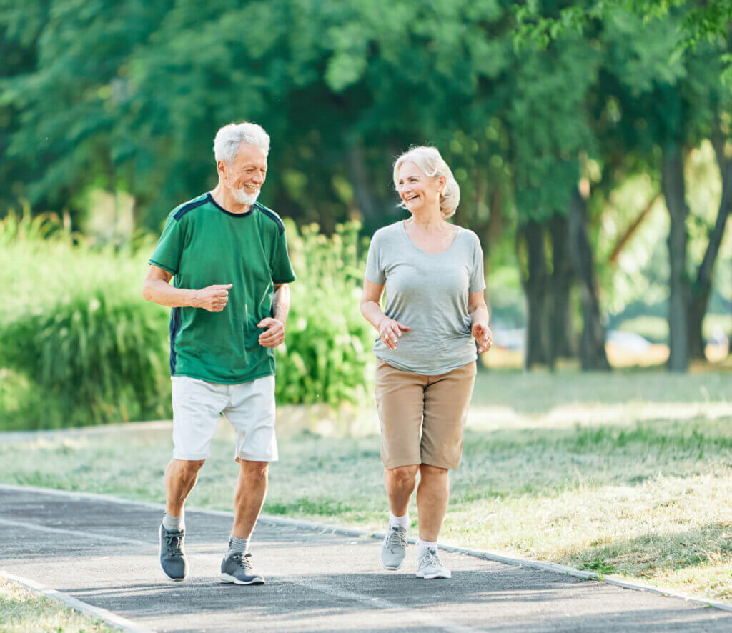Lächelndes, aktives Seniorenpaar beim gemeinsamen Joggen im Park